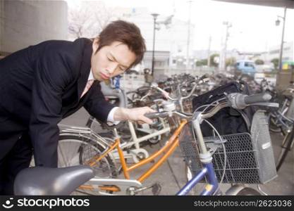 Japanese office worker checking a bicycle
