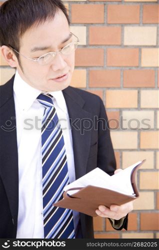 Japanese office worker checking a notebook