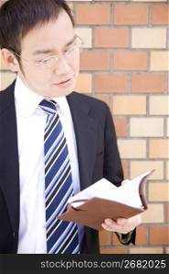 Japanese office worker checking a notebook