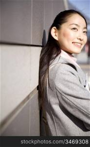 Japanese woman leaning against a wall