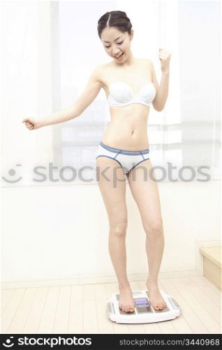 Japanese woman stepping on the scales