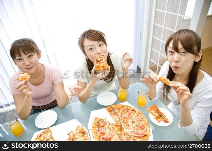 Japanese women eating a pizza