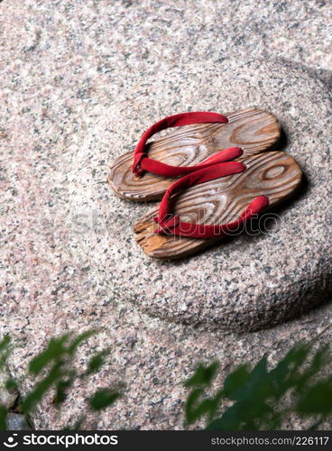 Japanese wooden sandal on the stone.