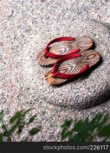 Japanese wooden sandal on the stone.