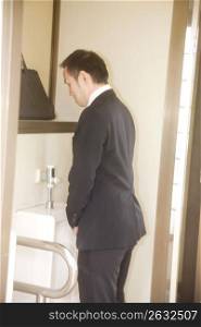 Japanese worker urinating in a public lavatory