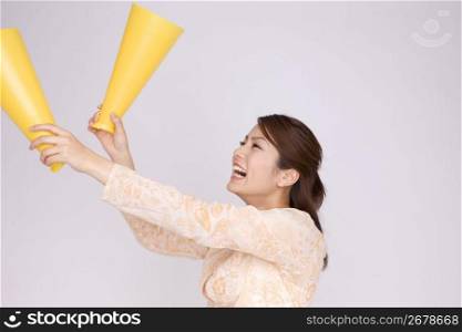 Japanese young woman cheering with megaphones
