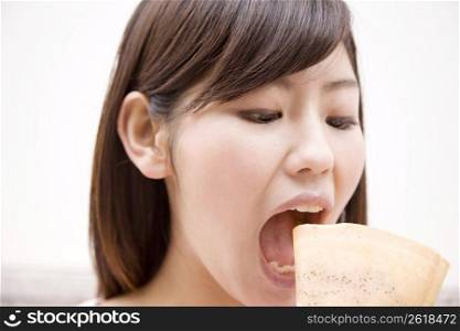 Japanese young woman eating crepe