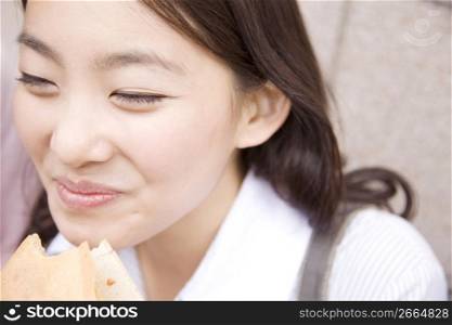 Japanese young woman eating crepe
