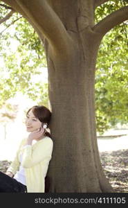 Japanese young woman listening to the music in the park