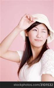 Japanese young woman putting on a hat
