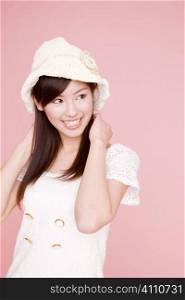 Japanese young woman putting on a hat