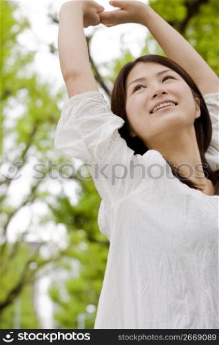 Japanese young woman stretching her arms