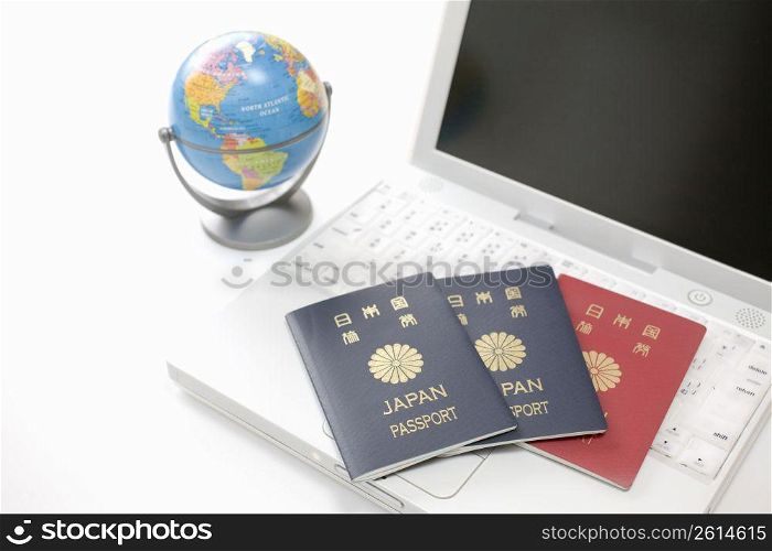 japanesse passports laying on a laptop keyboard