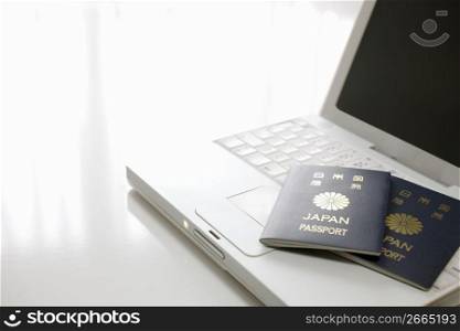 japanesse passports laying on a laptop keyboard