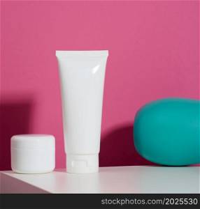 jar and empty white plastic tube for cosmetics on a pink background. Packaging for cream, gel, serum, advertising and product promotion, mock up