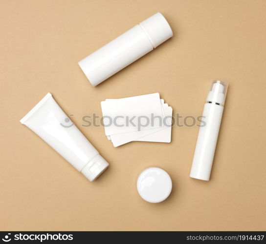 jar, bottle and empty white plastic tubes for cosmetics on a beige background. Packaging for cream, gel, serum, advertising and product promotion, mock up, top view