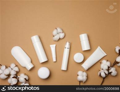 jar, bottle and empty white plastic tubes for cosmetics on a beige background. Packaging for cream, gel, serum, advertising and product promotion, mock up, top view