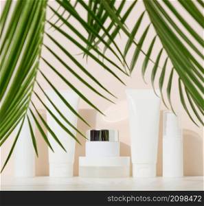 jar, bottle and empty white plastic tubes for cosmetics on a beige background. Packaging for cream, gel, serum, advertising and product promotion, mock up