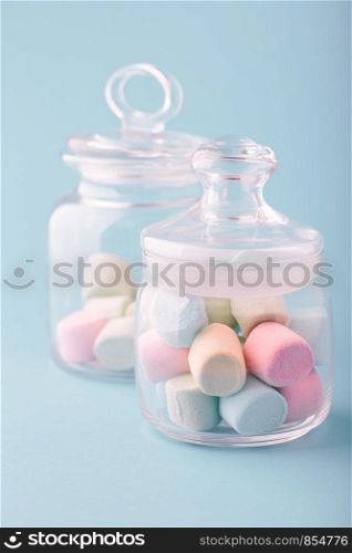 Jar filled with colorful marshmallows on plain background