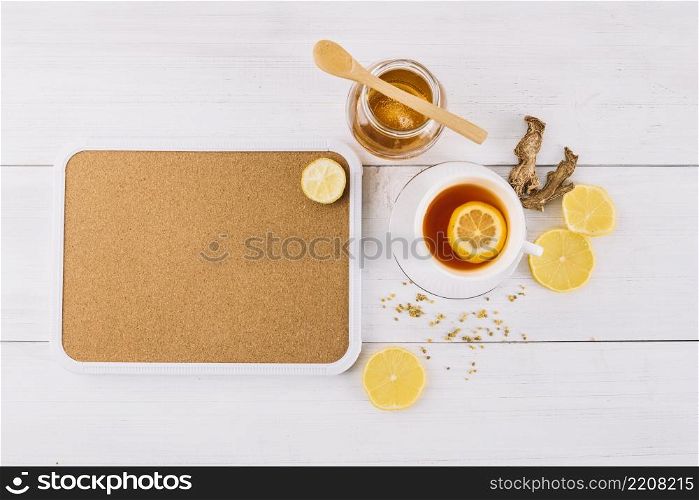 jar honey lemon tea near ginger wooden background