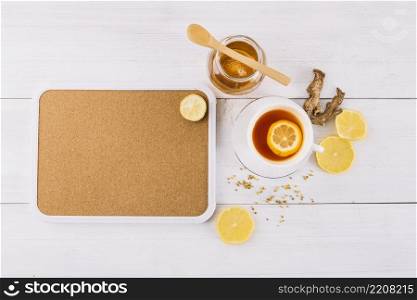 jar honey lemon tea near ginger wooden background