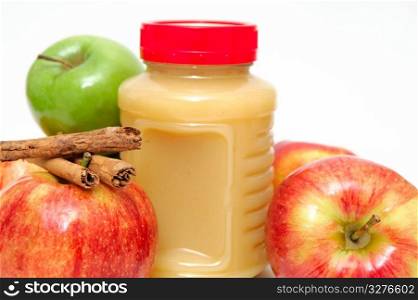 Jar Of Applesauce. Fresh Apples both green and red with a jar of store bought applesauce and cinnamon sticks