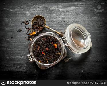 Jar of dried tea. On a black wooden background.. Jar of dried tea.