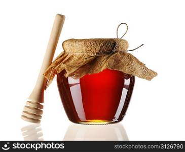 Jar of honey and dipper isolated over white