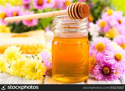 jar of honey with different flowers