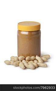 Jar of peanut butter and peanuts on white background