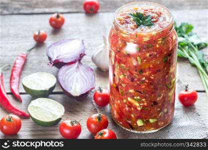 Jar of salsa with ingredients