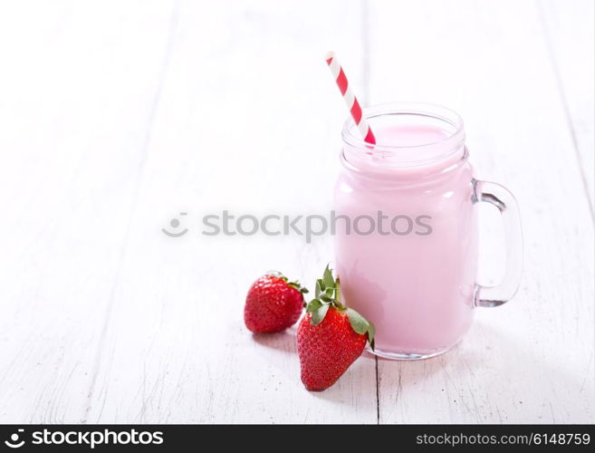 jar of strawberry smoothie on wooden table