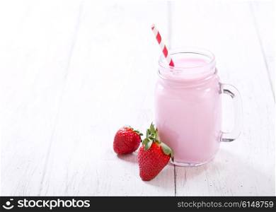 jar of strawberry smoothie on wooden table