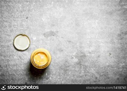 Jar with fresh mustard. On the stone table.. Jar with fresh mustard.