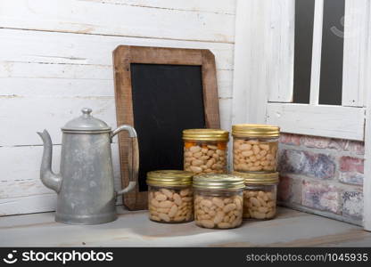 jars of delicious white Tarbais beans with chalkboard, near the window