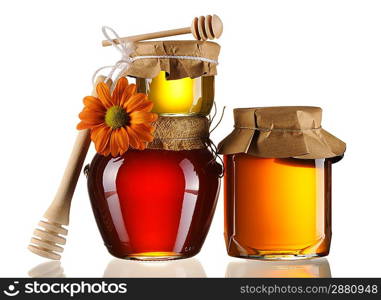 Jars of honey and dipper isolated over white