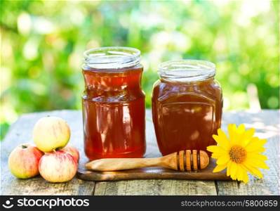 jars of honey on wooden table in the garden