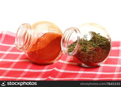 jars with pepper and lovage spices isolated white background