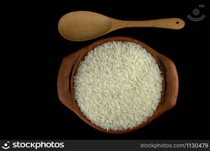 Jasmine rice in a clay pot and the wood ladle isolated on white background