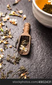 Jasmine tea in old wooden scoop , close up