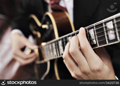 Jazz musician playing with electric guitar. Short depth-of-field.