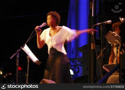 Jazz singer on outdoor stage, image is blurred by long exposure