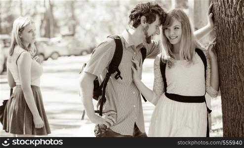 Jealous girl looking at flirting couple outdoor. Happy young woman and man couple dating. Summer romance affair.. Jealous girl looking at flirting couple outdoor.