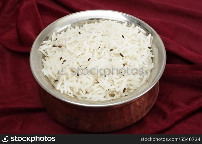 Jeera rice - long-grain basmati rice flavoured with fried cumin seeds - in a beaten copper and steel serving bowl