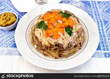 Jellied pork and beef with carrots and parsley on a plate, on a background of mustard linen tablecloths