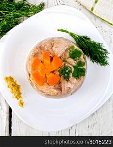 Jellied pork and beef with carrots and parsley on a plate with mustard and dill, a towel on the background of the wooden planks on top