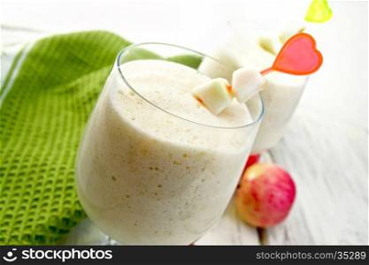 Jelly airy apple in wineglasses, red apples and a towel on the background of wooden boards