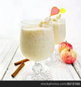 Jelly airy apple in wineglasses, red apples and cinnamon on a background of bright wooden boards