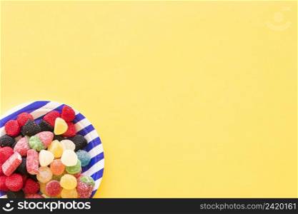 jelly candies striped plate yellow background