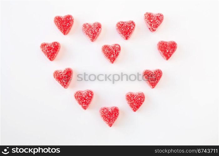 Jelly (gummy) sugar coated candy hearts arranged in the shape of a heart. Isolated on white.